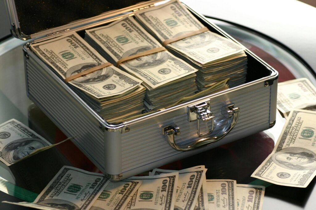 A silver metal case filled with stacks of $100 bills, secured with rubber bands.